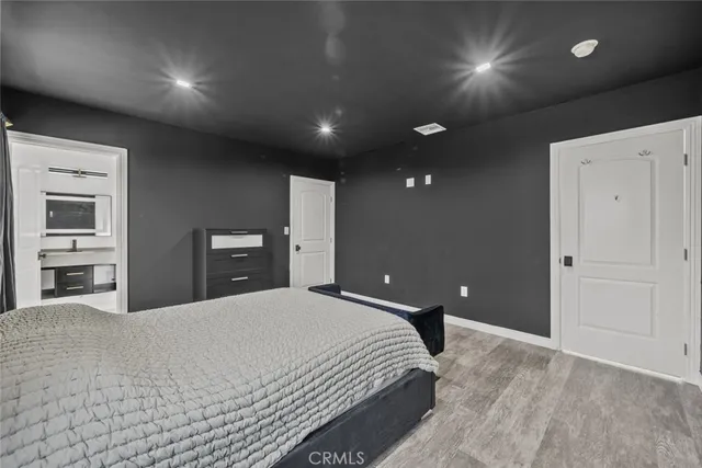 a large bedroom with a bed and a night stand