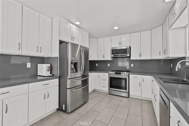 a kitchen with cabinets stainless steel appliances and a counter space
