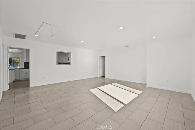 an empty room with kitchen view