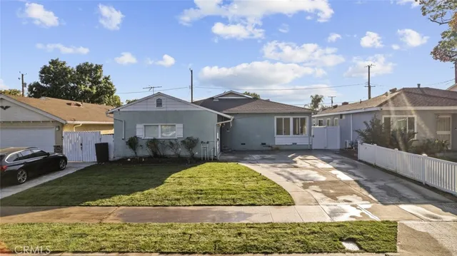a view of a white house with a big yard and large trees
