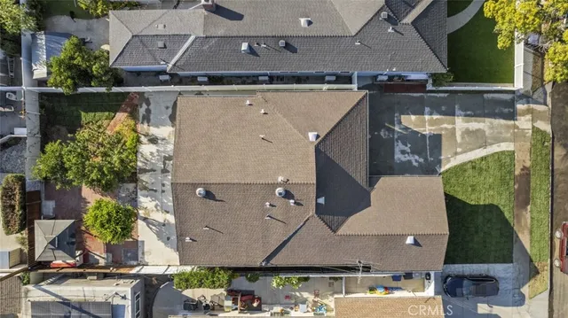an aerial view of a house with a yard and a large tree