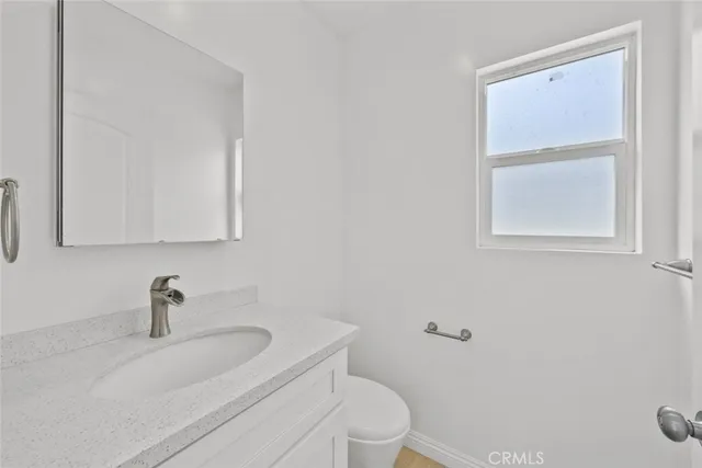 a bathroom with a sink a toilet and a window