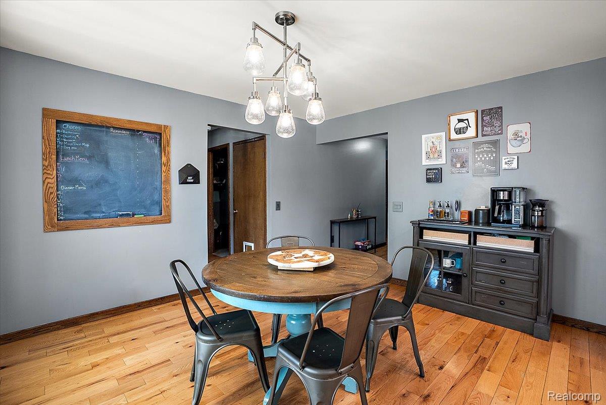 60718 Campground Road Washington, MI 48094 - Photo 12 of 37 Dining area featuring wood-finish flooring and a contemporary multi-light fixture