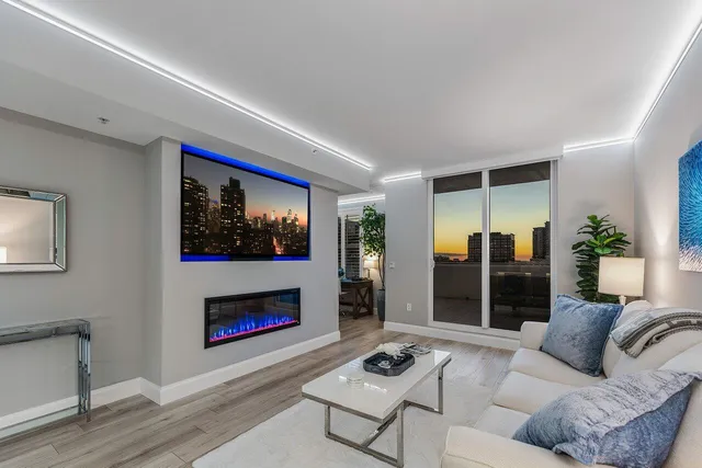 a living room with furniture a fireplace and a large window