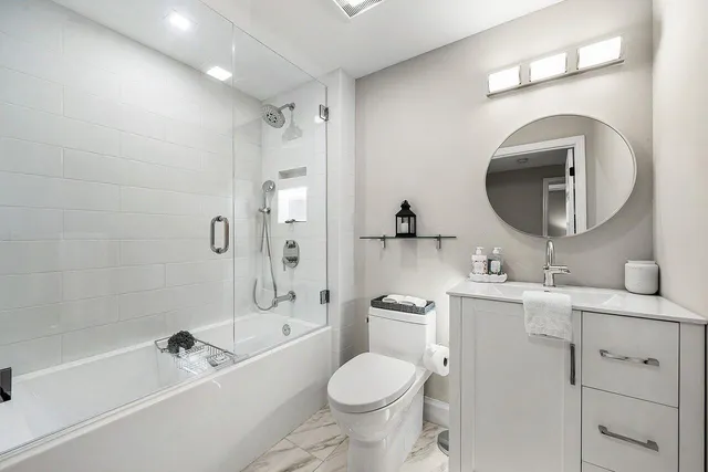 a bathroom with a toilet sink vanity tub and shower