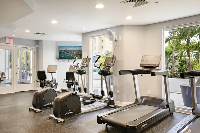 a room with gym equipment and large windows