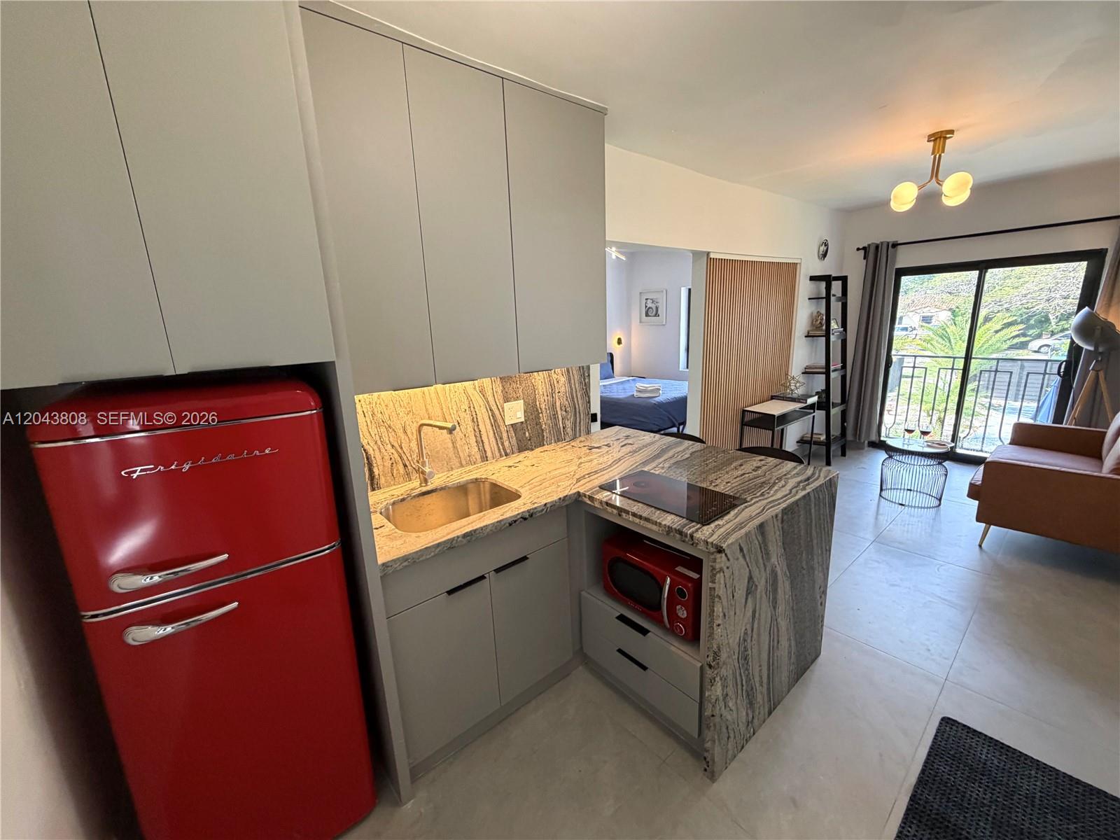 2134 Southwest 11th Street Miami, FL 33135 - Photo 9 of 13 a kitchen with stainless steel appliances granite countertop a stove top oven a sink dishwasher and wooden cabinets