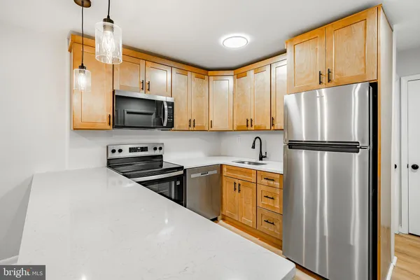 a kitchen with stainless steel appliances a refrigerator sink and microwave