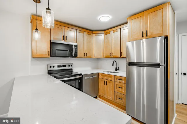 a kitchen with stainless steel appliances a refrigerator sink and microwave