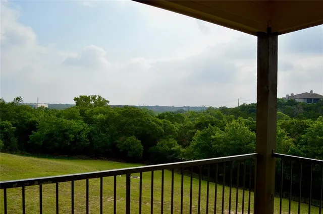 a view of a balcony with yard