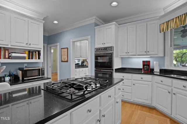 a kitchen with white cabinets and appliances