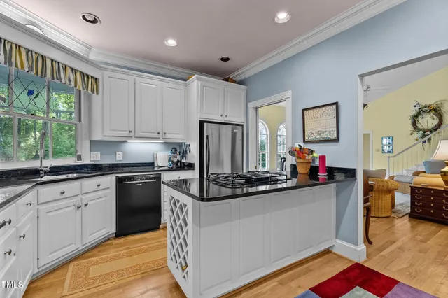 a kitchen that has a lot of cabinets a sink and appliances in it