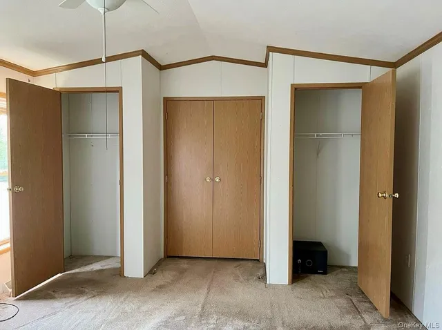 a view of an empty room with cabinet and a hallway