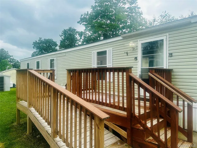 a view of a house with backyard and deck