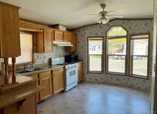 a large kitchen with a large window and stainless steel appliances