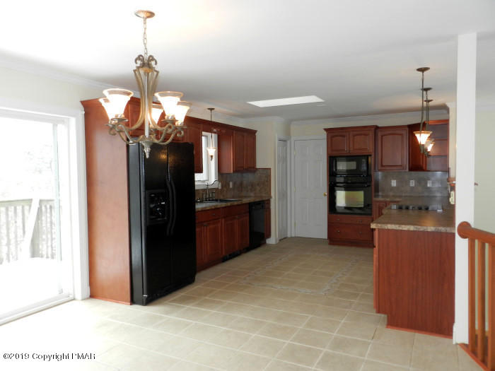 5918 Decker Road Bushkill, PA 18324 - Photo 4 of 31 a kitchen with stainless steel appliances kitchen island granite countertop a refrigerator and a sink