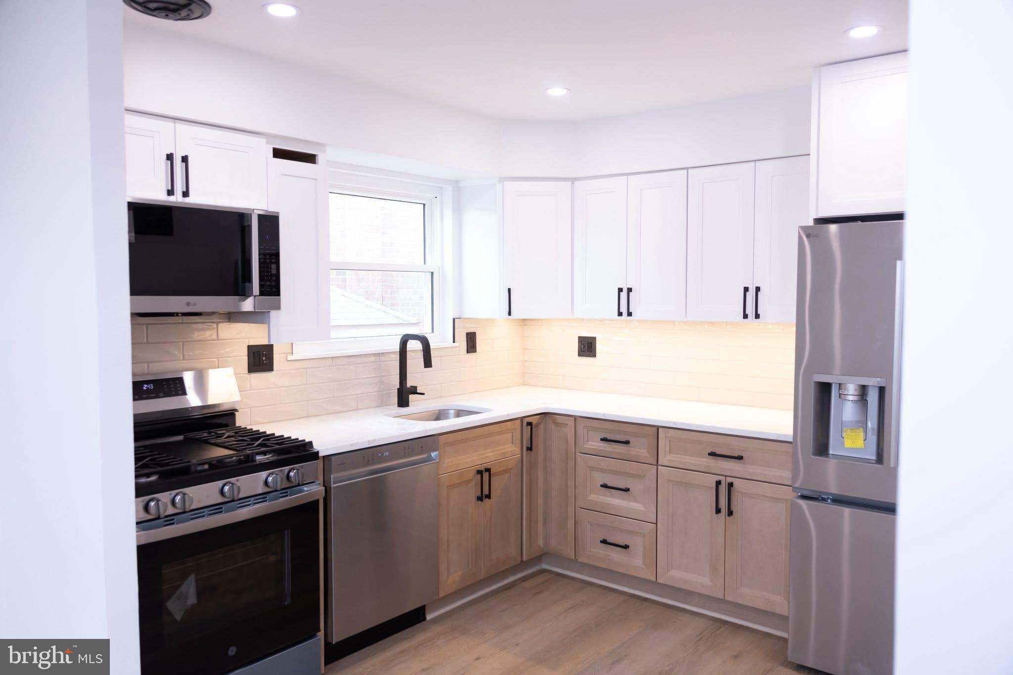 a kitchen with cabinets appliances and a sink