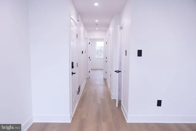 a view of a hallway with wooden floor