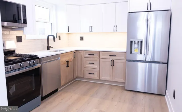a kitchen with stainless steel appliances a refrigerator sink and cabinets
