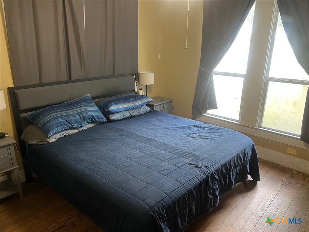 408 Hubbard Street Yoakum, TX 77995 - Photo 16 of 23 a bedroom with a bed and wooden floor