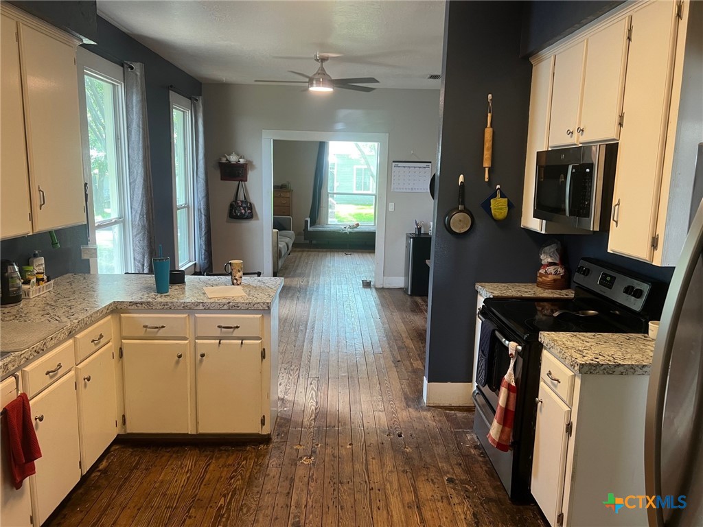 408 Hubbard Street Yoakum, TX 77995 - Photo 6 of 23 a kitchen with cabinets and wooden floor