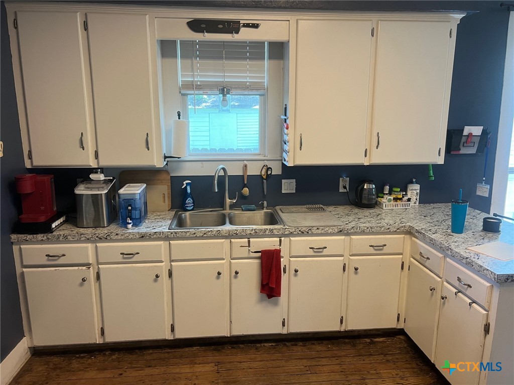 408 Hubbard Street Yoakum, TX 77995 - Photo 8 of 23 a kitchen with granite countertop a sink and cabinets