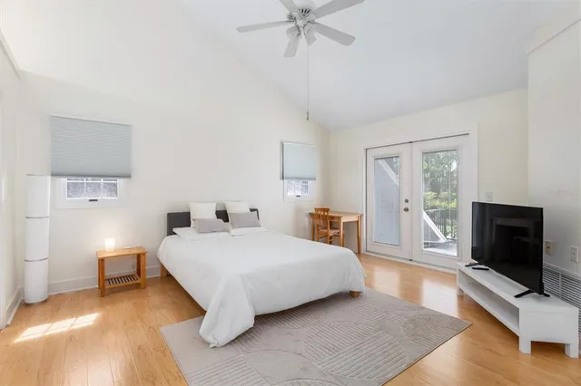 a spacious bedroom with a bed and a flat screen tv