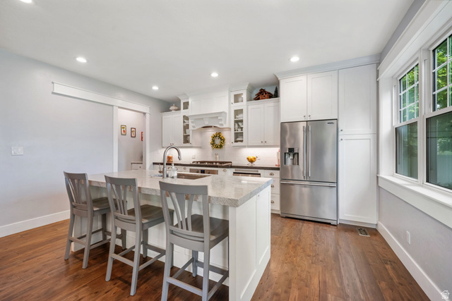 357 South 320 W Street Lindon, UT 84042 - Photo 6 of 41 Kitchen featuring wood-finish flooring, white cabinetry, a stainless steel refrigerator, a center island with sink, and recessed lighting