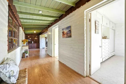 a view of hallway with furniture and wooden floor