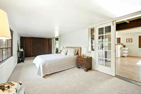 a bedroom with a bed and glass door