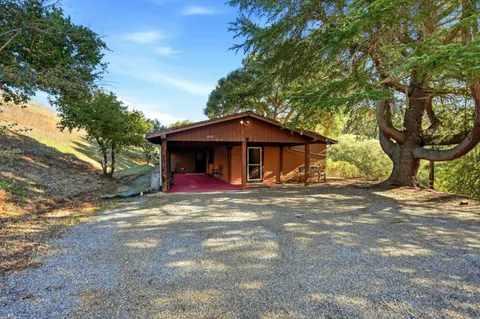 a view of a house with a yard and large tree