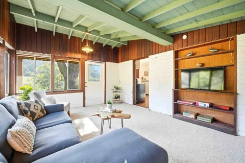 a living room with furniture a air conditioner vent and a large window