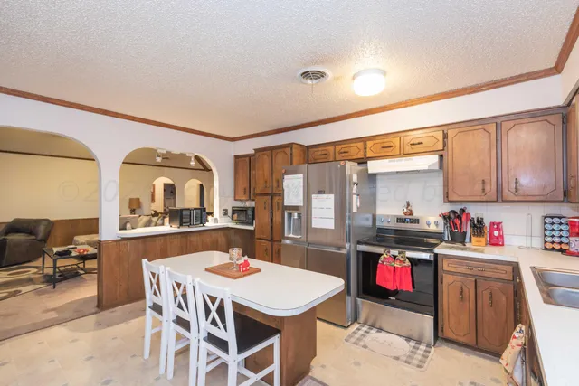 a kitchen with refrigerator a table and chairs