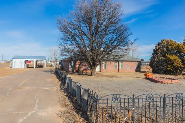 a view of a house with a small yard and wooden fence