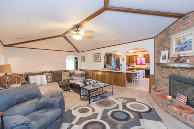a living room with furniture a fireplace and a large mirror
