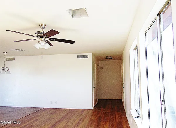 a view of a room with wooden floor and a ceiling fan