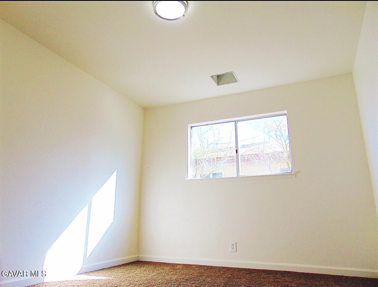 1260 North El Prado Street Ridgecrest, CA 93555 - Photo 7 of 28 a view of an empty room with wooden floor and a window