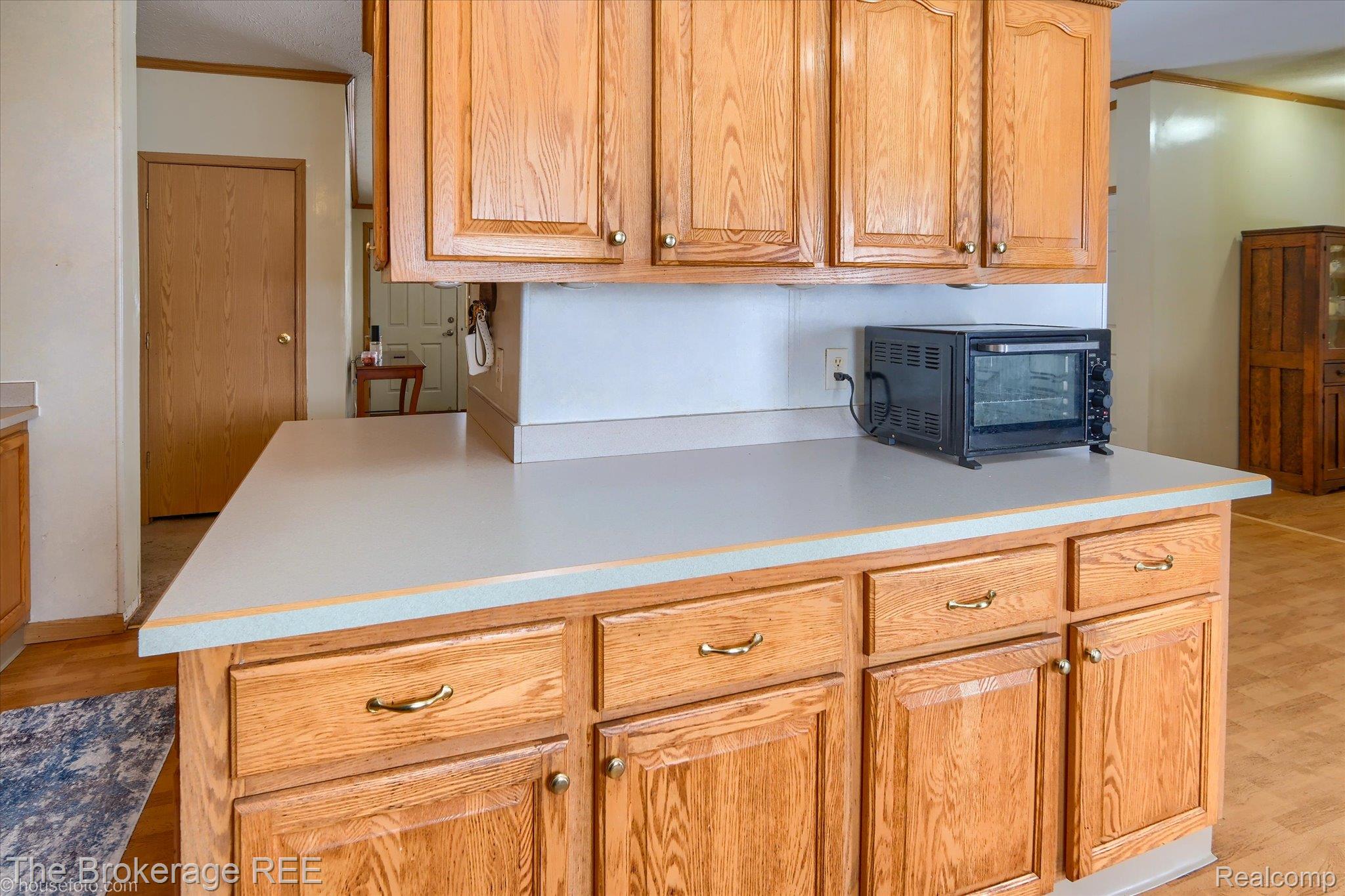 8247 North Center Road Mount Morris, MI 48458 - Photo 23 of 46 Kitchen featuring light countertops, light wood-style flooring, ornamental molding, and brown cabinetry
