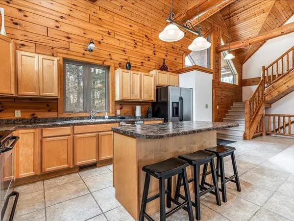 a view of house with backyard and trees in the background