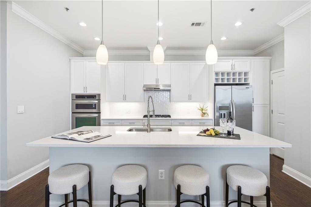 270 17th Street Northwest, Unit 4306 Atlanta, GA 30363 - Photo 6 of 37 a kitchen with stainless steel appliances granite countertop a dining table chairs and white cabinets