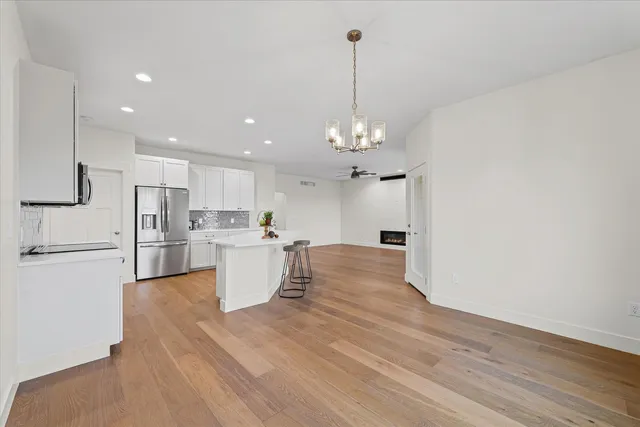 a kitchen with refrigerator and white wooden cabinets