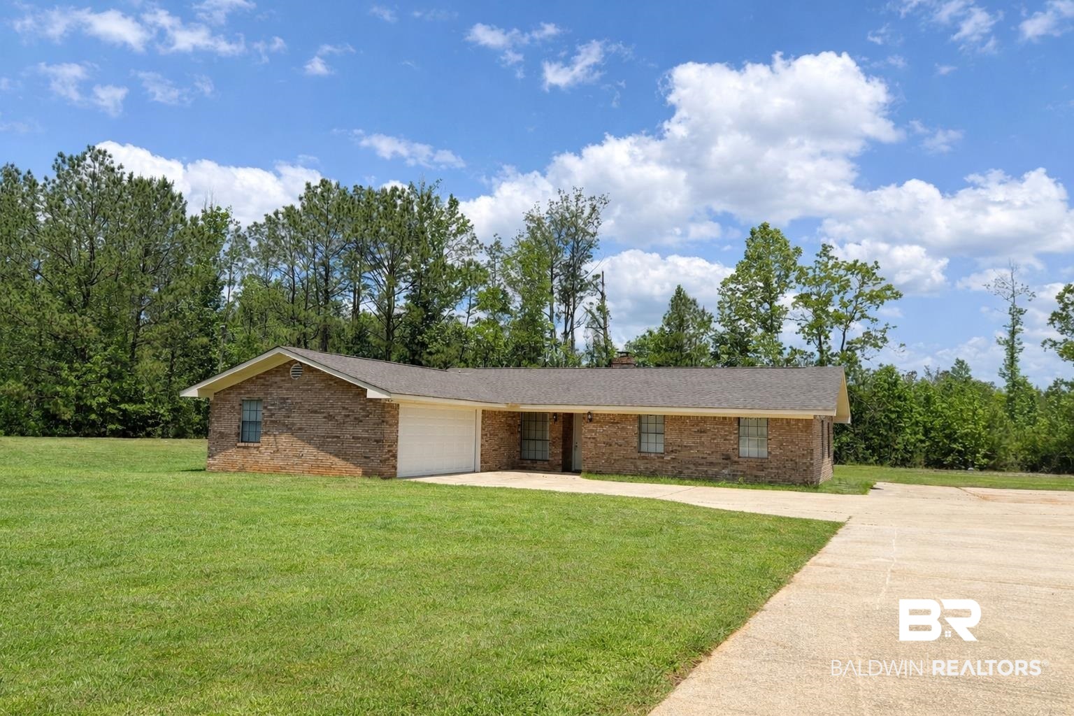 294 Wolf Log Road Flomaton, AL 36441 - Photo 1 of 14 Single story home featuring a garage, concrete driveway, a front yard, and brick siding