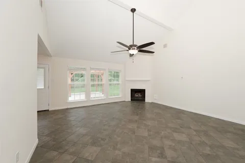 an empty room with fireplace and windows
