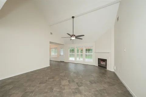 an empty room with wooden floor closet and windows