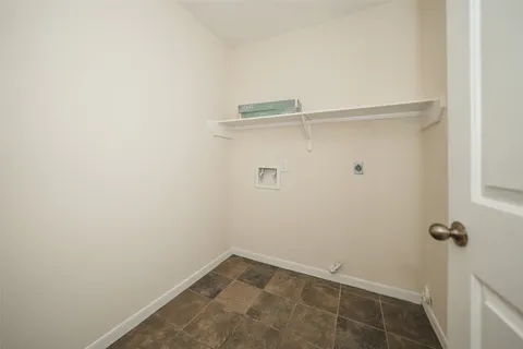 an empty room with wooden floor ceiling fan and windows