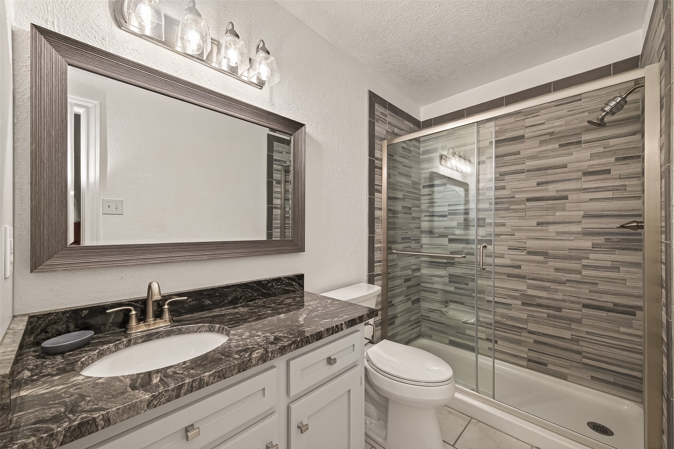 6131 Hampton Way Court Spring, TX 77389 - Photo 34 of 50 a bathroom with a granite countertop toilet sink and mirror