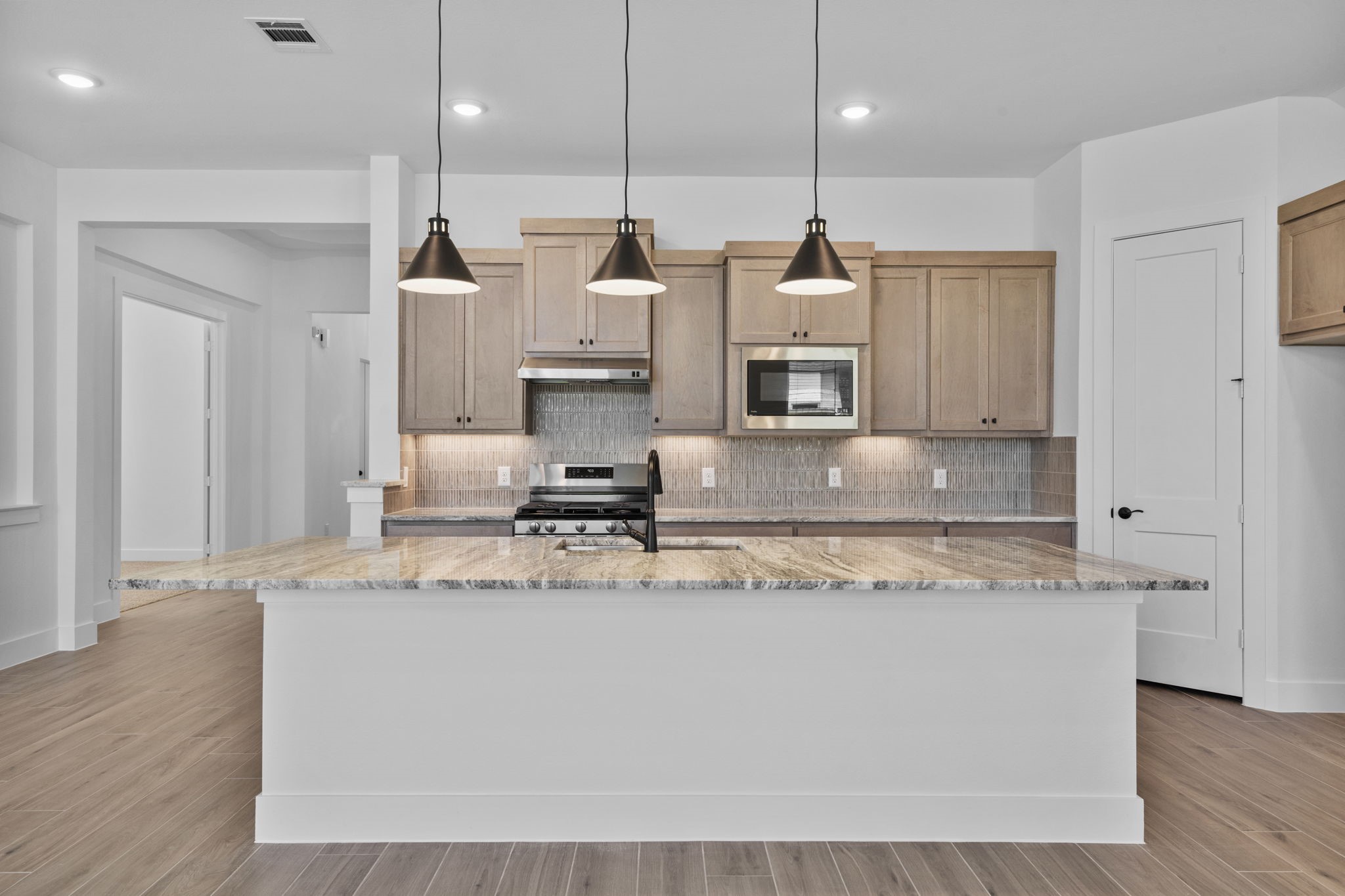 2910 Peach Vly Road Fulshear, TX 77423 - Photo 17 of 35 a large kitchen with stainless steel appliances kitchen island a large counter top and a wooden floors