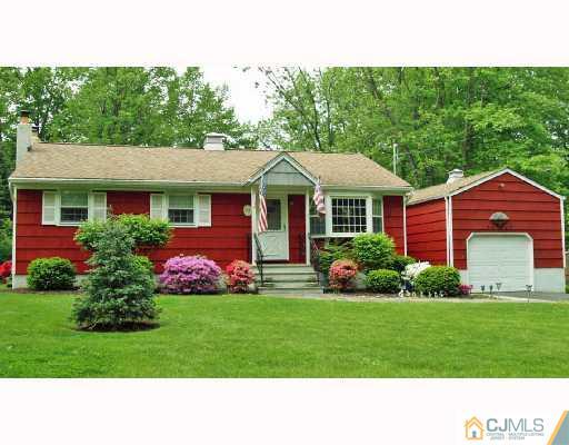 47 Highland Road Colonia, NJ 07067 - Photo 1 of 2 a front view of a house with a garden and plants