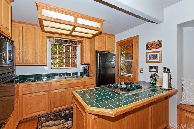 659 Blue Jay Canyon Road Blue Jay, CA 92317 - Photo 17 of 40 a kitchen with stainless steel appliances granite countertop a sink stove and refrigerator