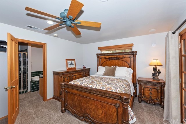 659 Blue Jay Canyon Road Blue Jay, CA 92317 - Photo 21 of 40 a bedroom with a bed and a chandelier